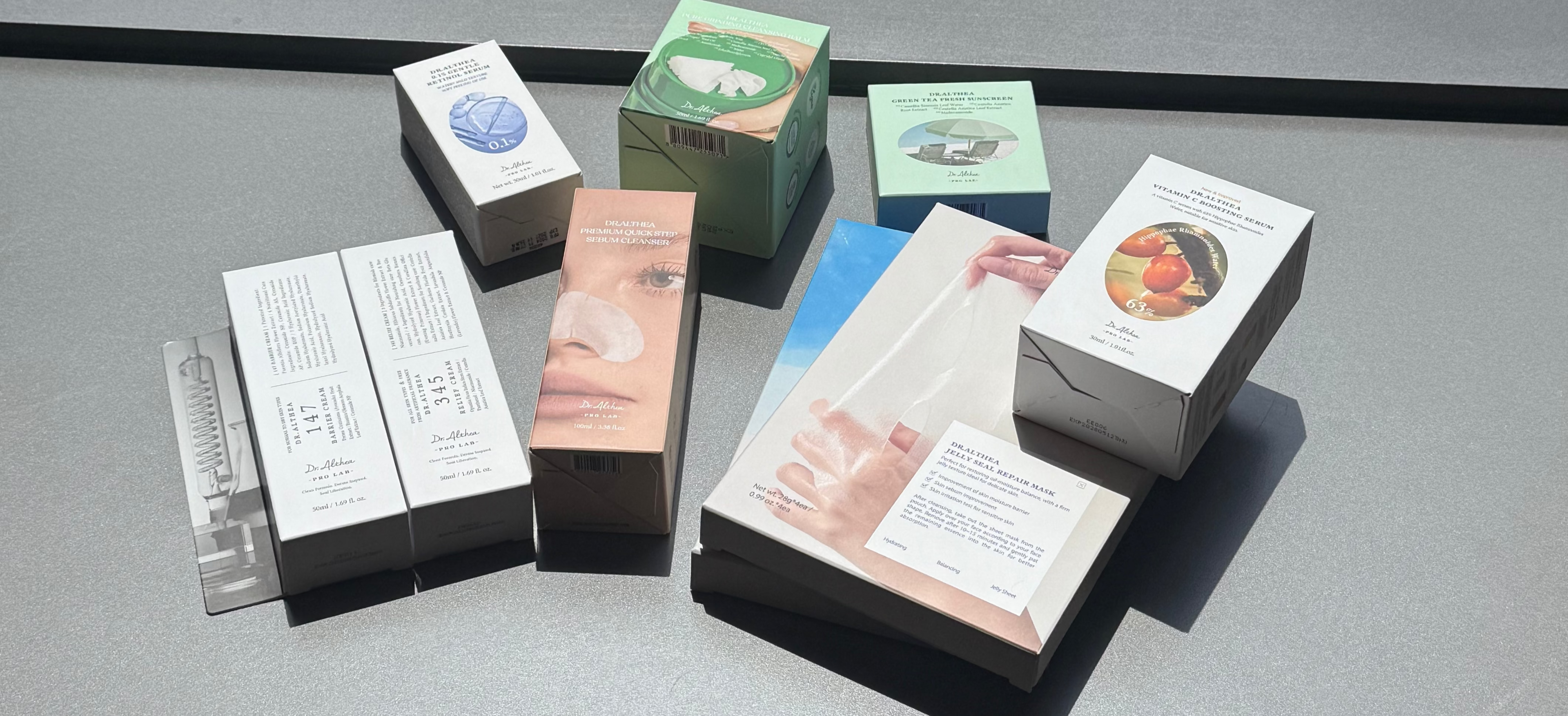 Collection of small boxes with various designs on a reflective surface with a cityscape background